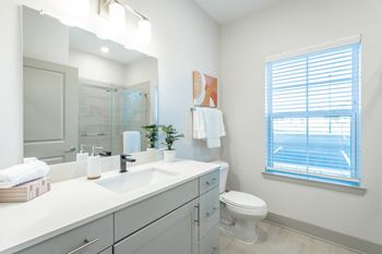 Bathroom with quartz countertops, designer lighting, and undermount sinks